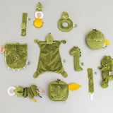 Doudou Mr. Dino Trixie présenté avec les jouets bébé assortis de la collection